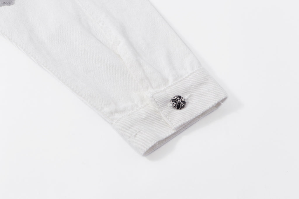 White jacket sleeve cuff with metal button and visible stitching detail