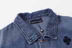 Blue denim jacket collar close-up with button and embroidered dark patch