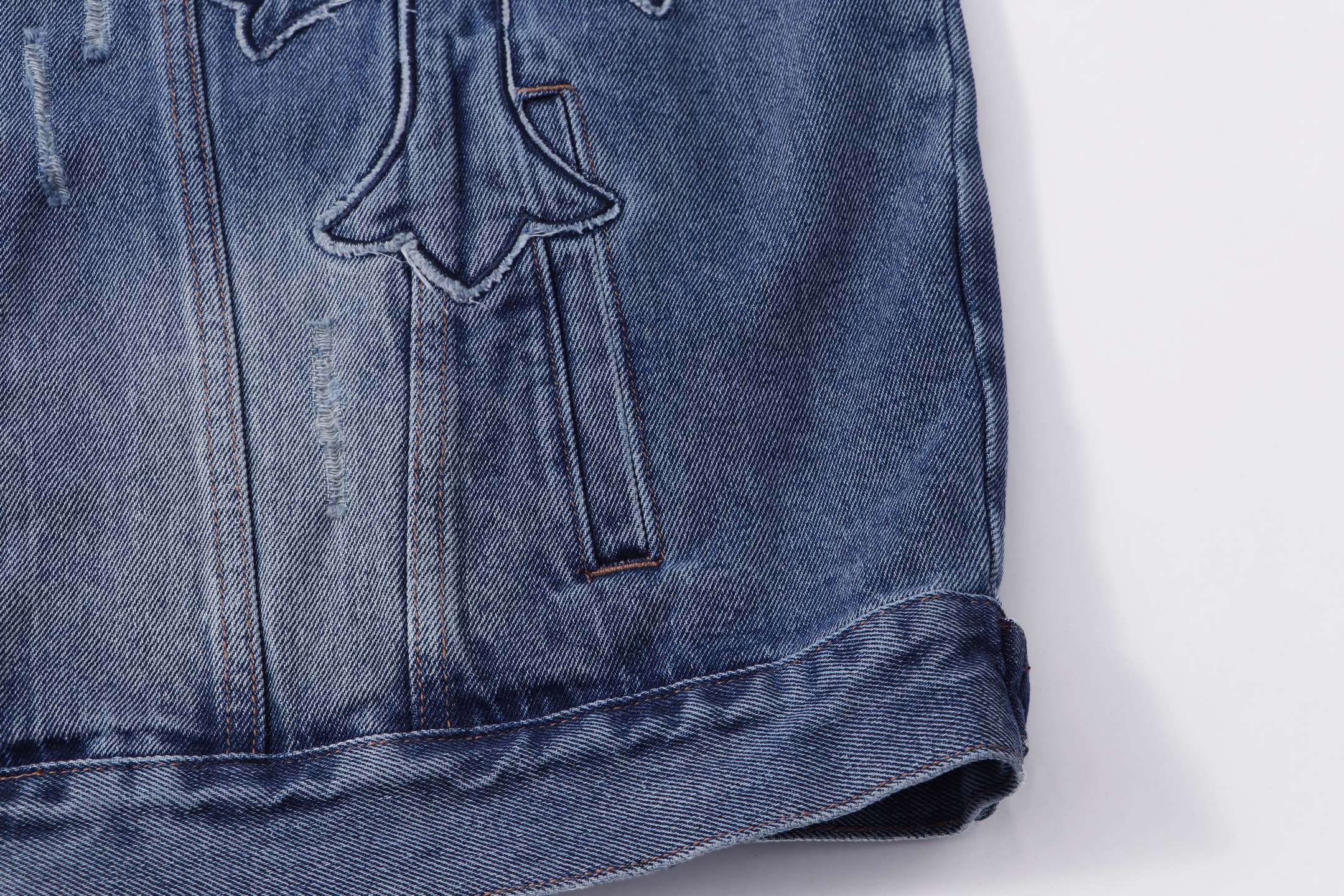 Blue denim jacket lower front with button placket and embroidered cross