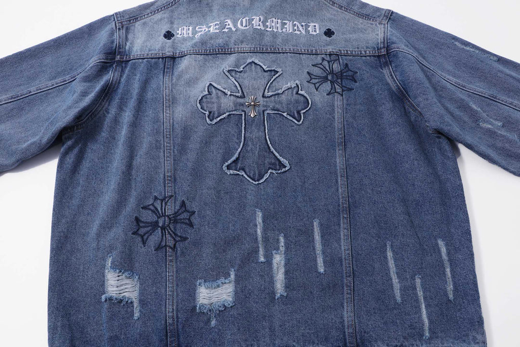 Blue denim jacket back with cross outline and small star and floral patches