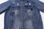 Blue denim jacket front view with large cross and embroidered patch details