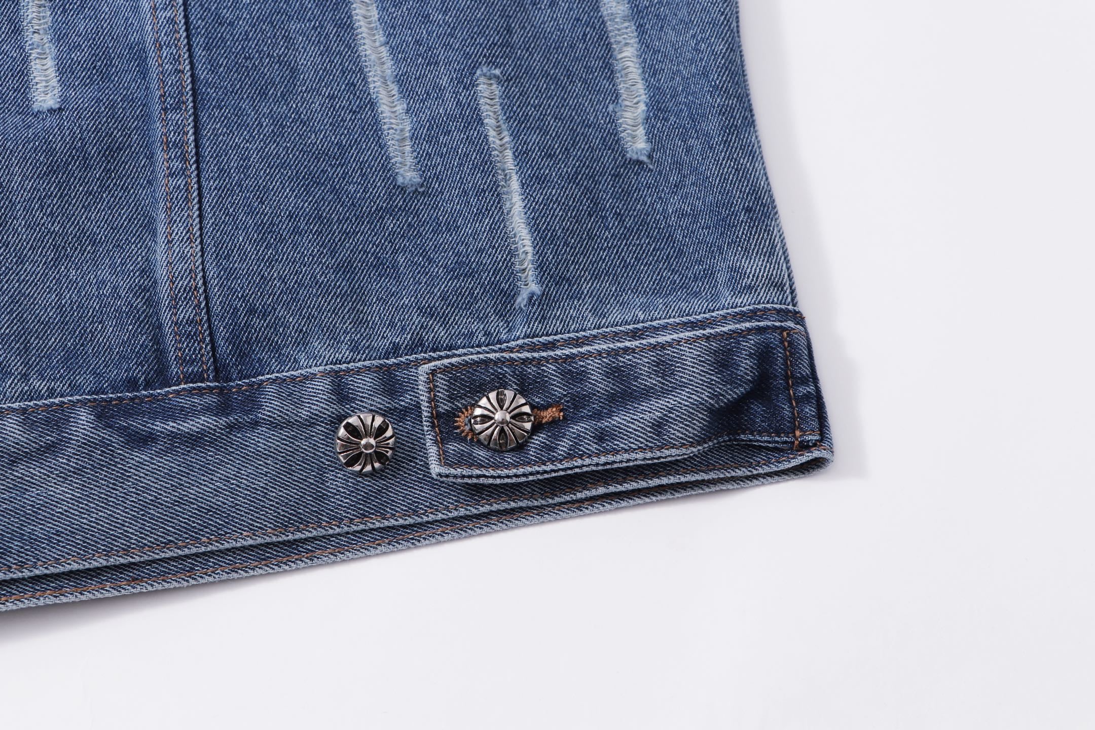 Blue denim jacket hem with decorative metal buttons and stitched border