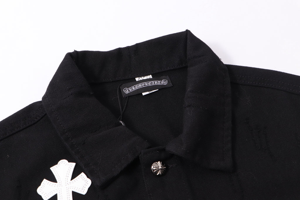 Black denim jacket neckline close-up with inner label and white cross patch