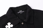 Black denim jacket neckline close-up with inner label and white cross patch