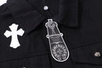 Black denim jacket close-up at collar with white cross patch and hanging tag