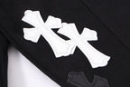 Black denim jacket sleeve detail with large white cross applique and stitched edges