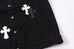 Black denim jacket lower front detail with white cross patch and snap buttons