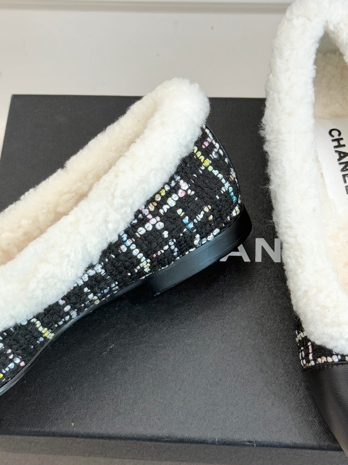 Women’s Chanel loafer detail, black tweed side with white sherpa trim and logo hardware
