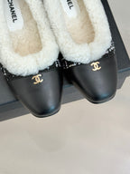 Women’s Chanel loafers close-up, white sherpa lining and black leather with Chanel emblem