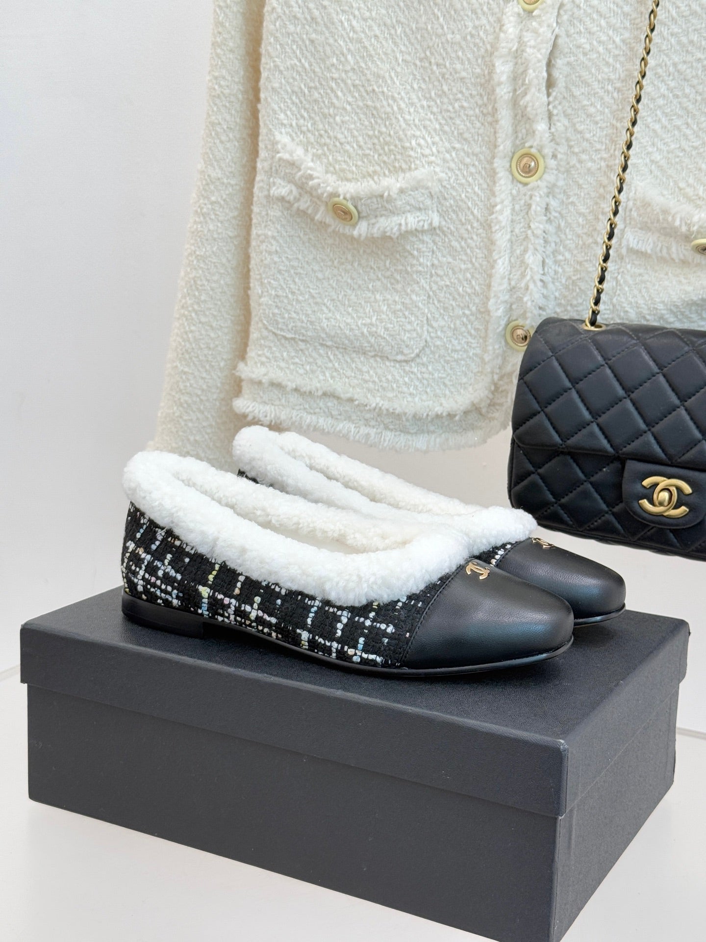 Women’s Chanel loafer slippers with black leather finish and white sherpa trim