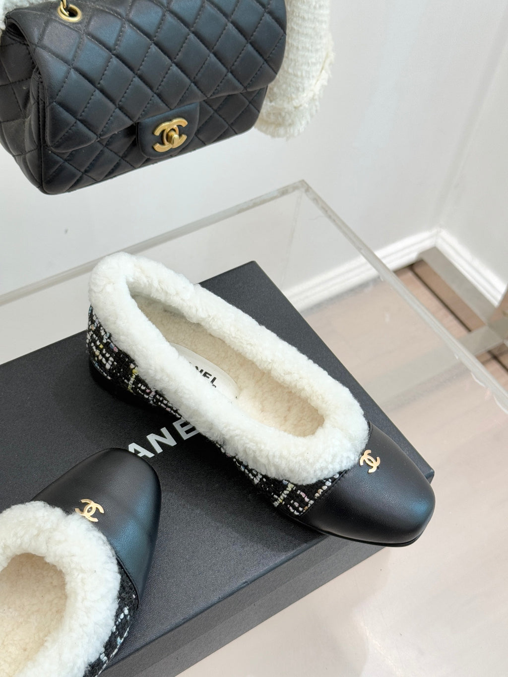 Women’s Chanel loafers with white sherpa trim and black leather plus tweed side band