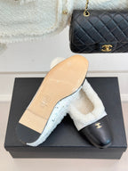 Women's Chanel slip-on flat with black leather upper and visible tan sole