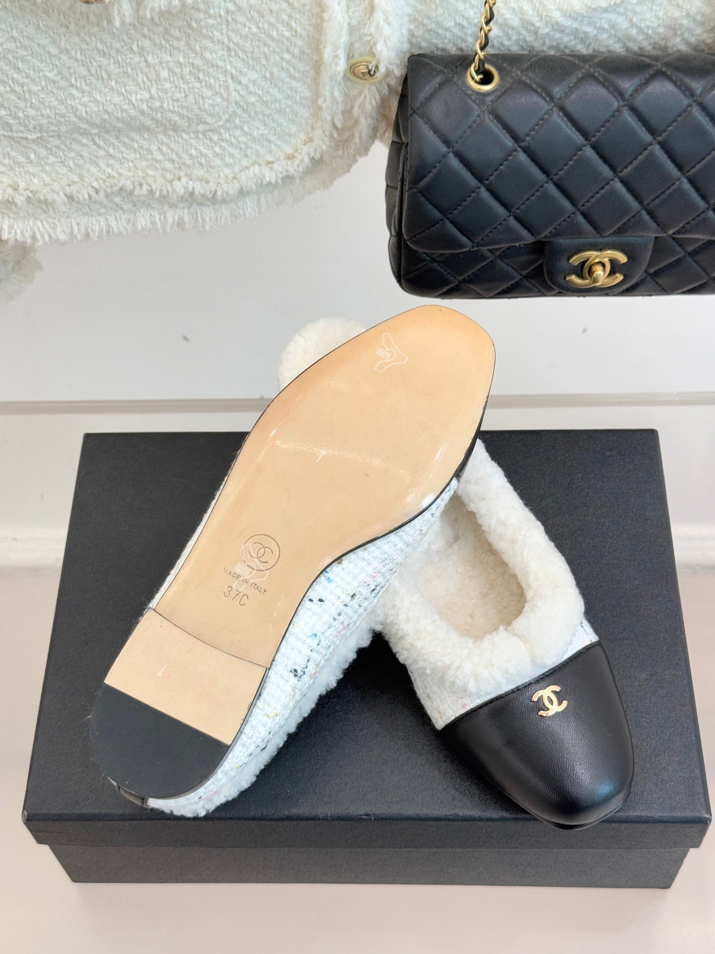 Women's Chanel slip-on flat with black leather upper and visible tan sole