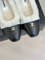 Women's Chanel flats with black leather fronts and white fleece interior lining