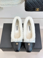 Women's Chanel shearling mules with white fleece tops and black leather toe caps