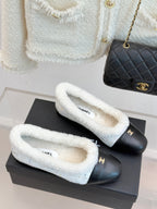 Pair of women's Chanel flats with black toes and light blue shearling lining
