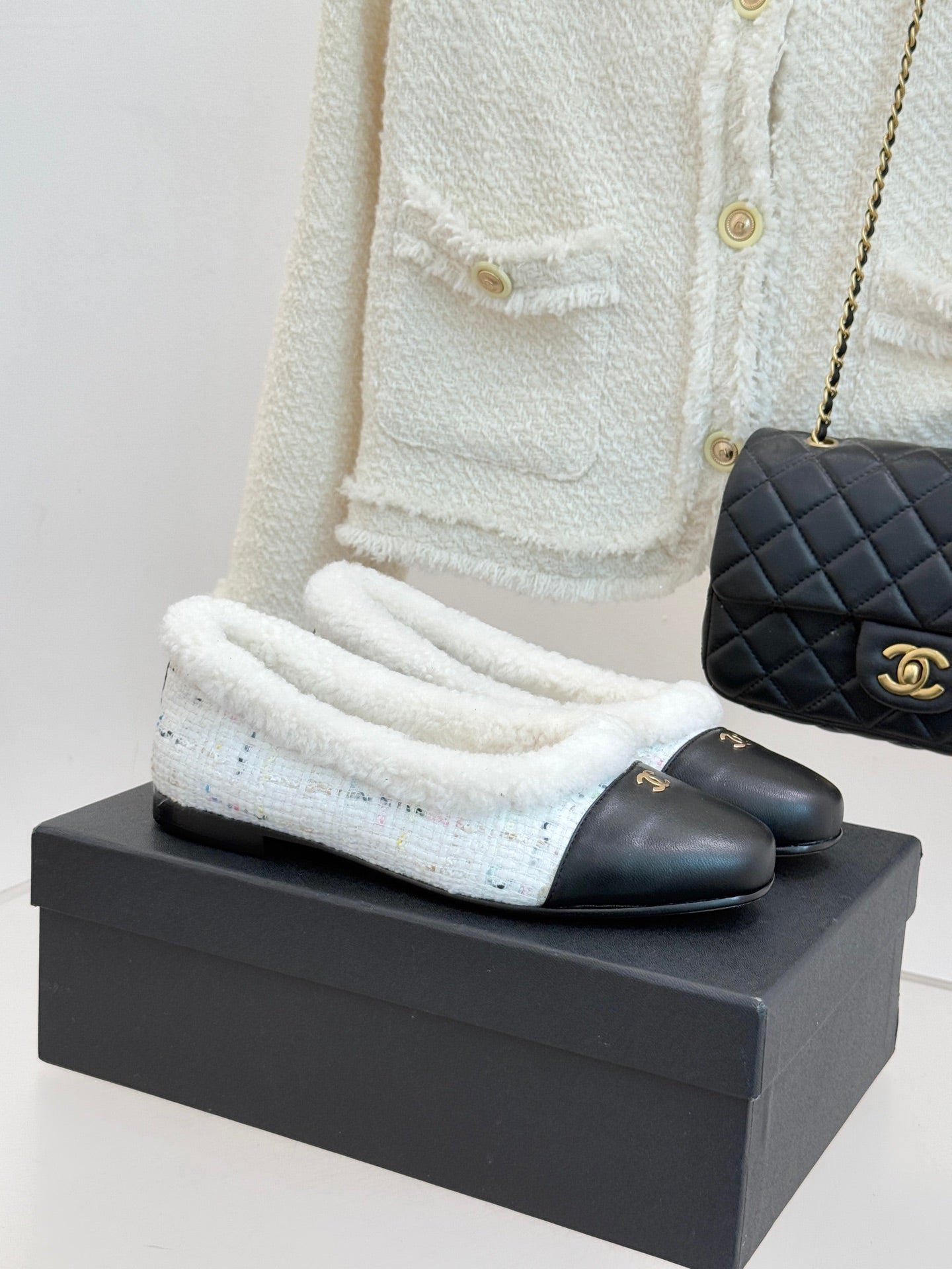 Women's Chanel flats with black leather exterior and light blue shearling trim