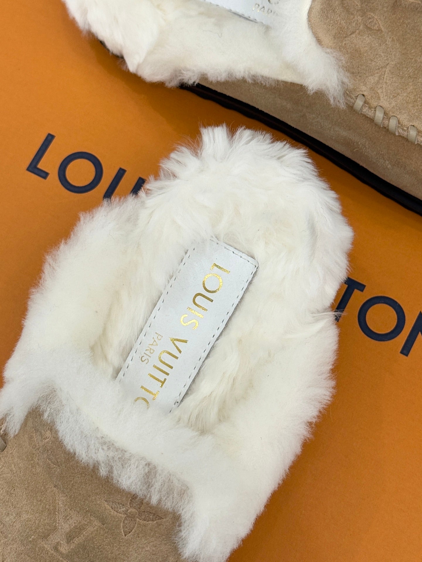 Louis Vuitton ladies shearling slide, white faux-fur strap with brand label and tan footbed