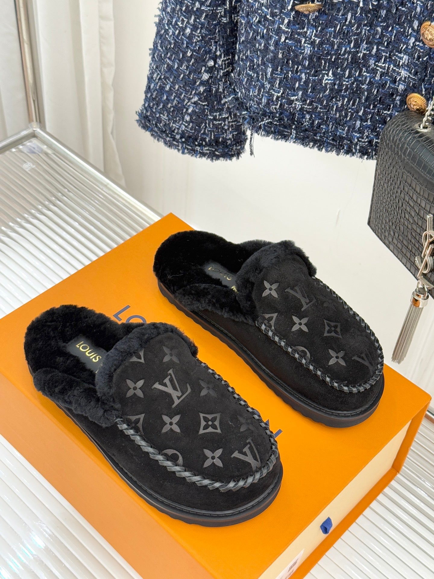 Louis Vuitton black monogram slip-on loafers on an orange box