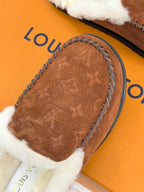 Brown suede top of shearling loafer with embossed pattern and white fur cuff