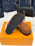 Brown suede loafer with white fur trim and ridged outsole