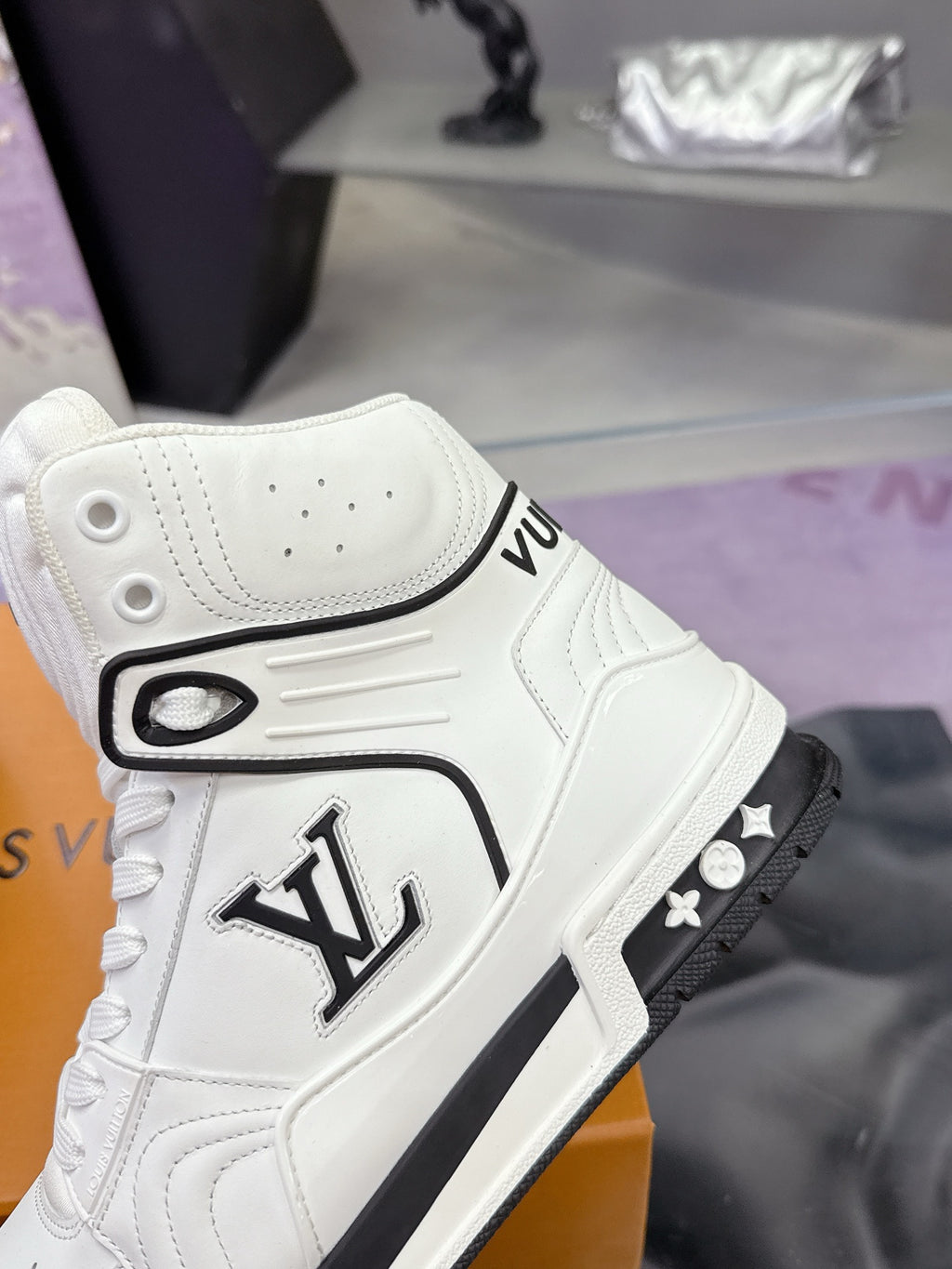 White Louis Vuitton high-top sneaker side view with LV emblem and black sole trim
