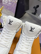 Close-up of white Louis Vuitton high-top sneakers with LV crest on the tongues