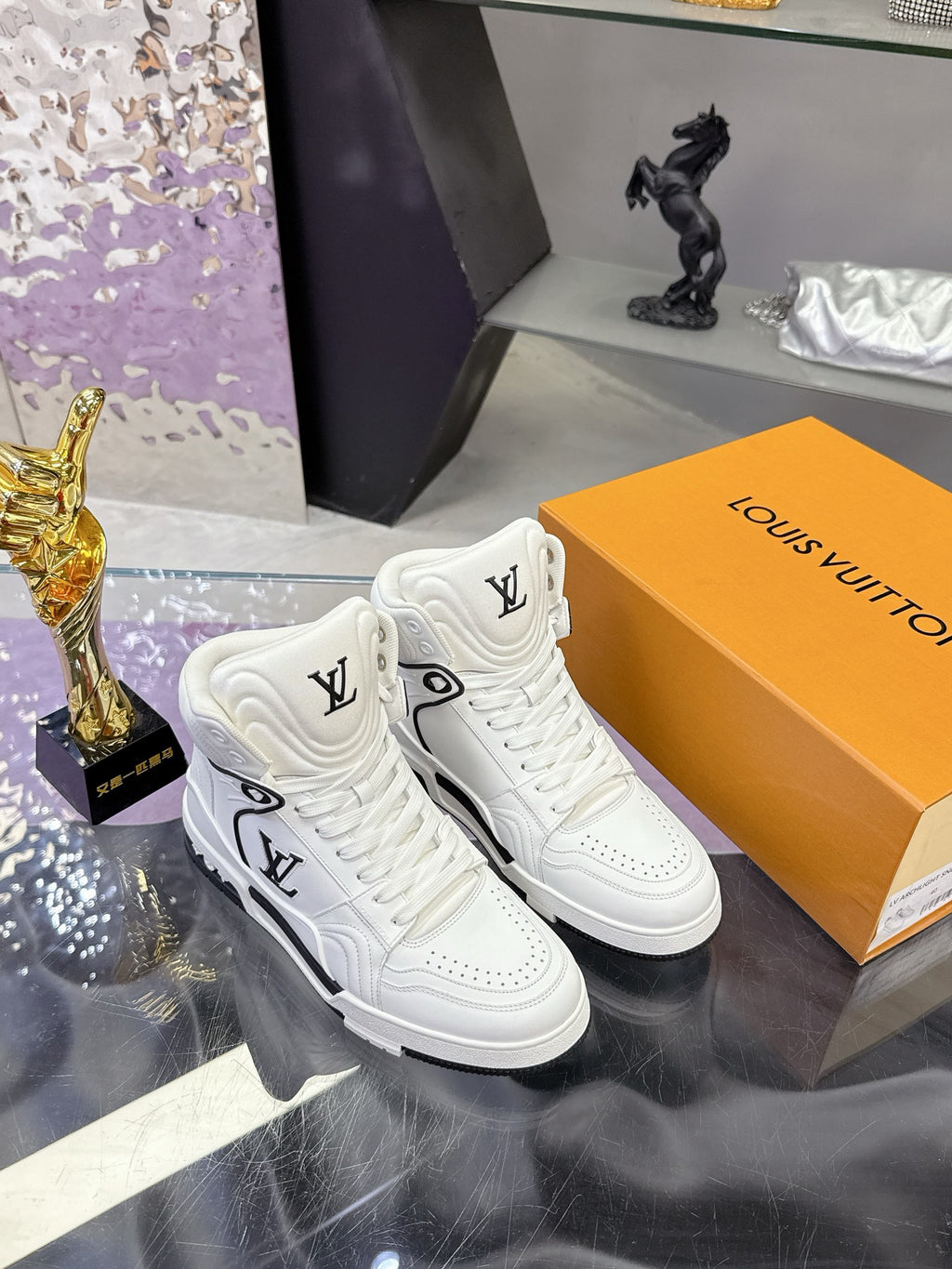 White Louis Vuitton high-top sneakers with embroidered LV logos and black soles