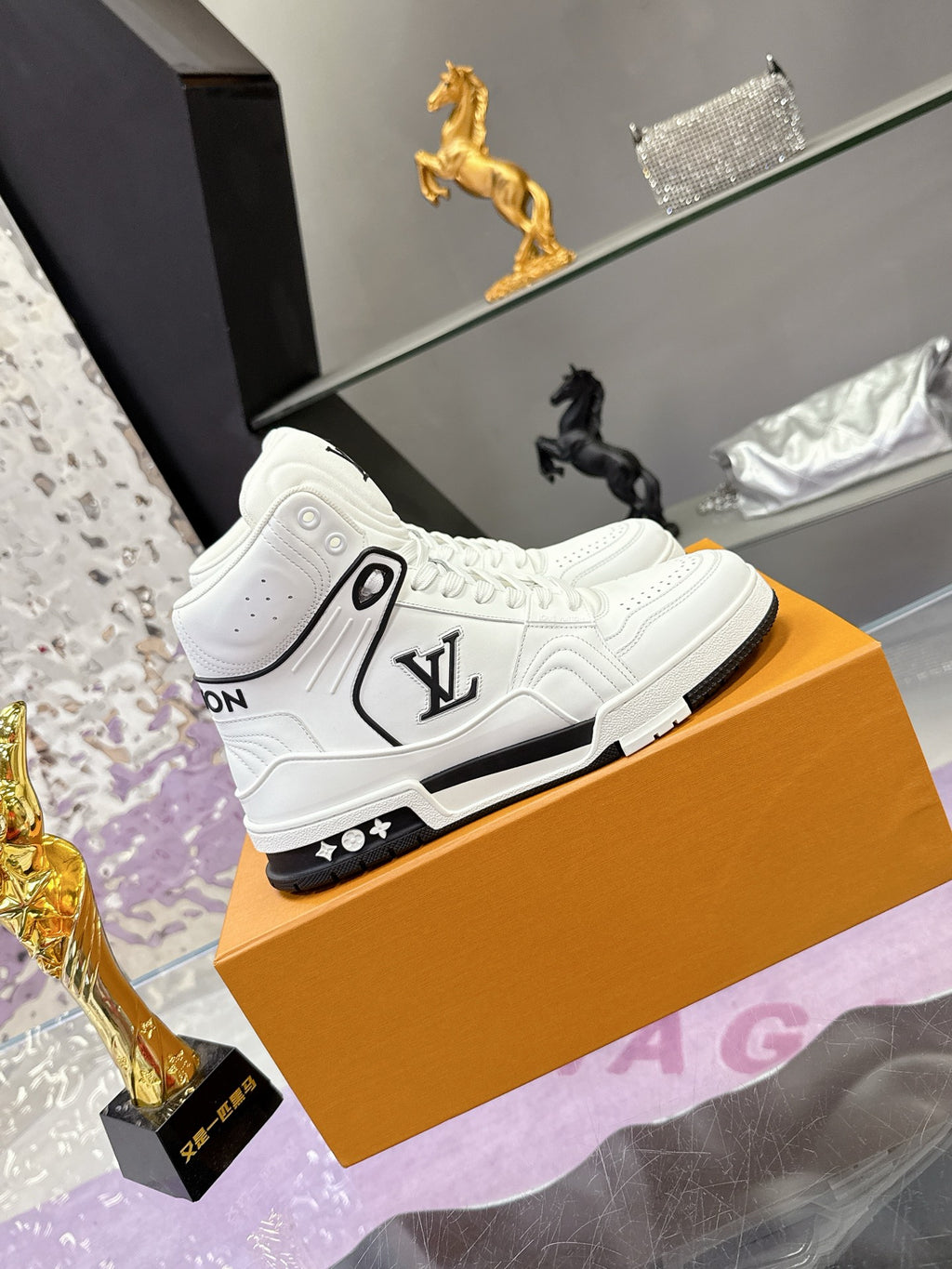 White Louis Vuitton high-top sneakers showing side logo and black rubber sole