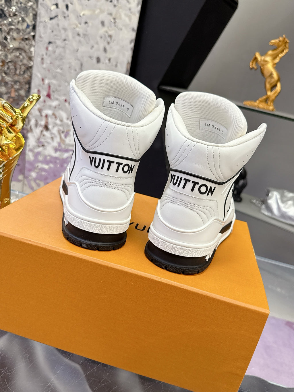 White Louis Vuitton high-top sneakers rear view with branded heel tab and black sole