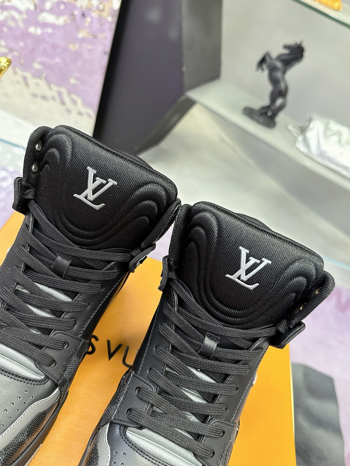 Pair of Louis Vuitton high-top sneakers, black with LV tongue logos and lace-up laces