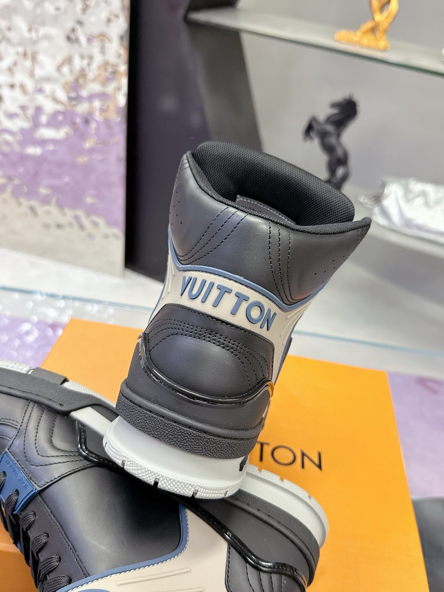 Louis Vuitton high-top sneakers with black heel collar and gray upper, padded ankle
