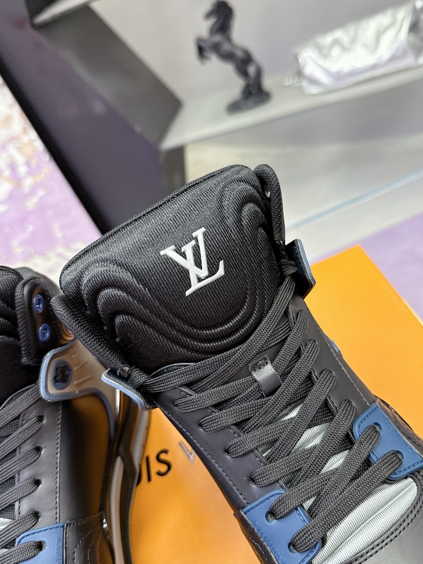 Louis Vuitton high-top sneaker tongue with LV logo and gray-blue lace details