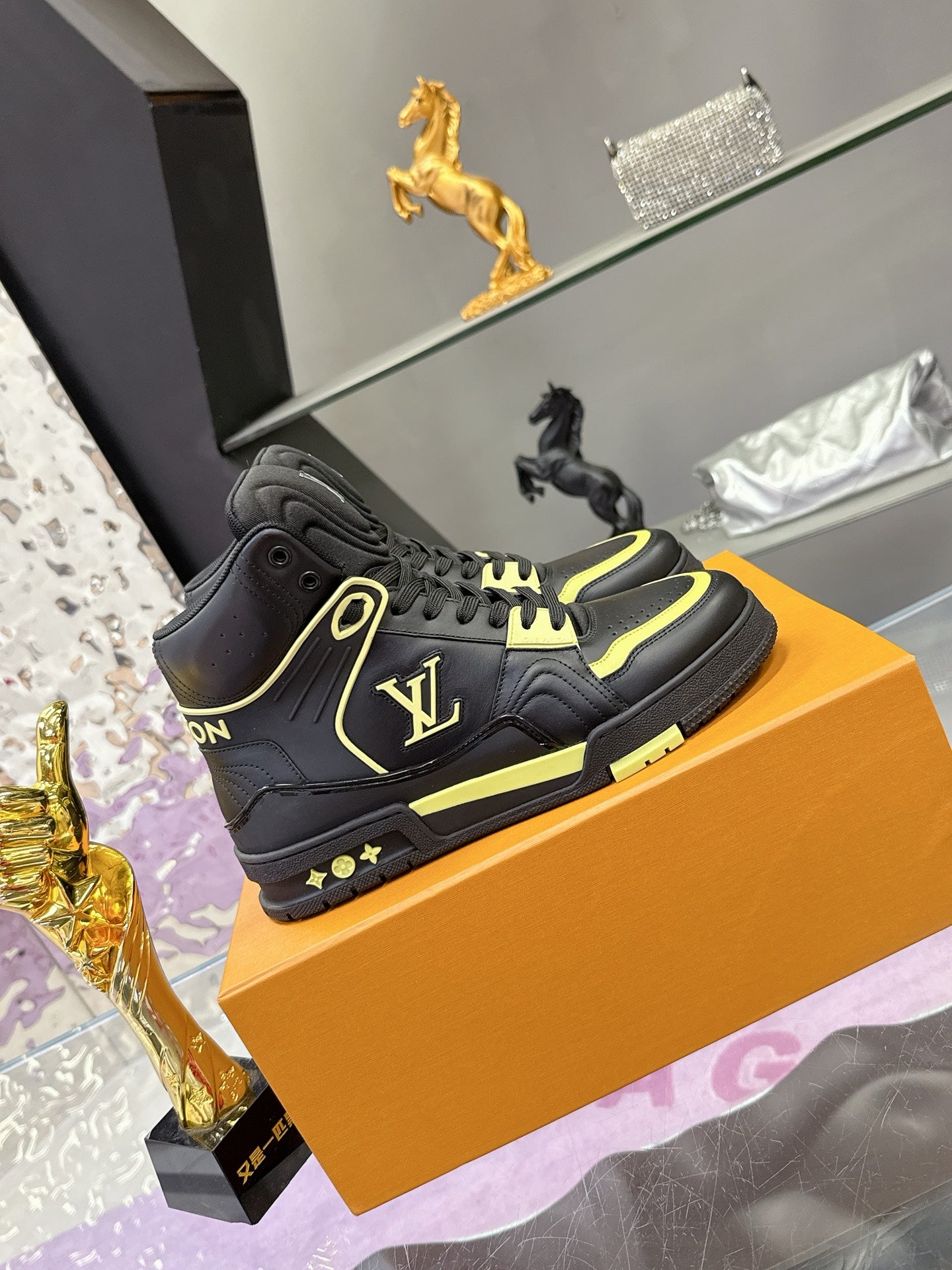 Black high-top sneakers with neon yellow piping, lace-up, and logo patch