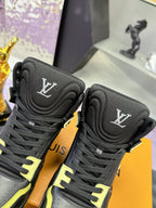 Black high-top sneakers detail view: LV logo patch and neon yellow trim