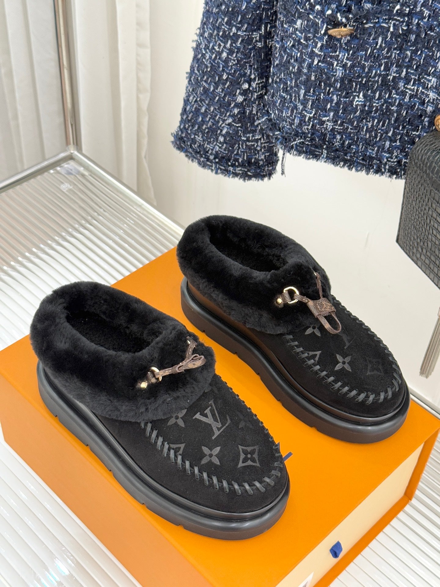 Black shearling loafers with monogram pattern and gold-tone bit detail, side-by-side view