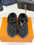 Black shearling loafers with monogram uppers and gold-tone hardware, front view pair