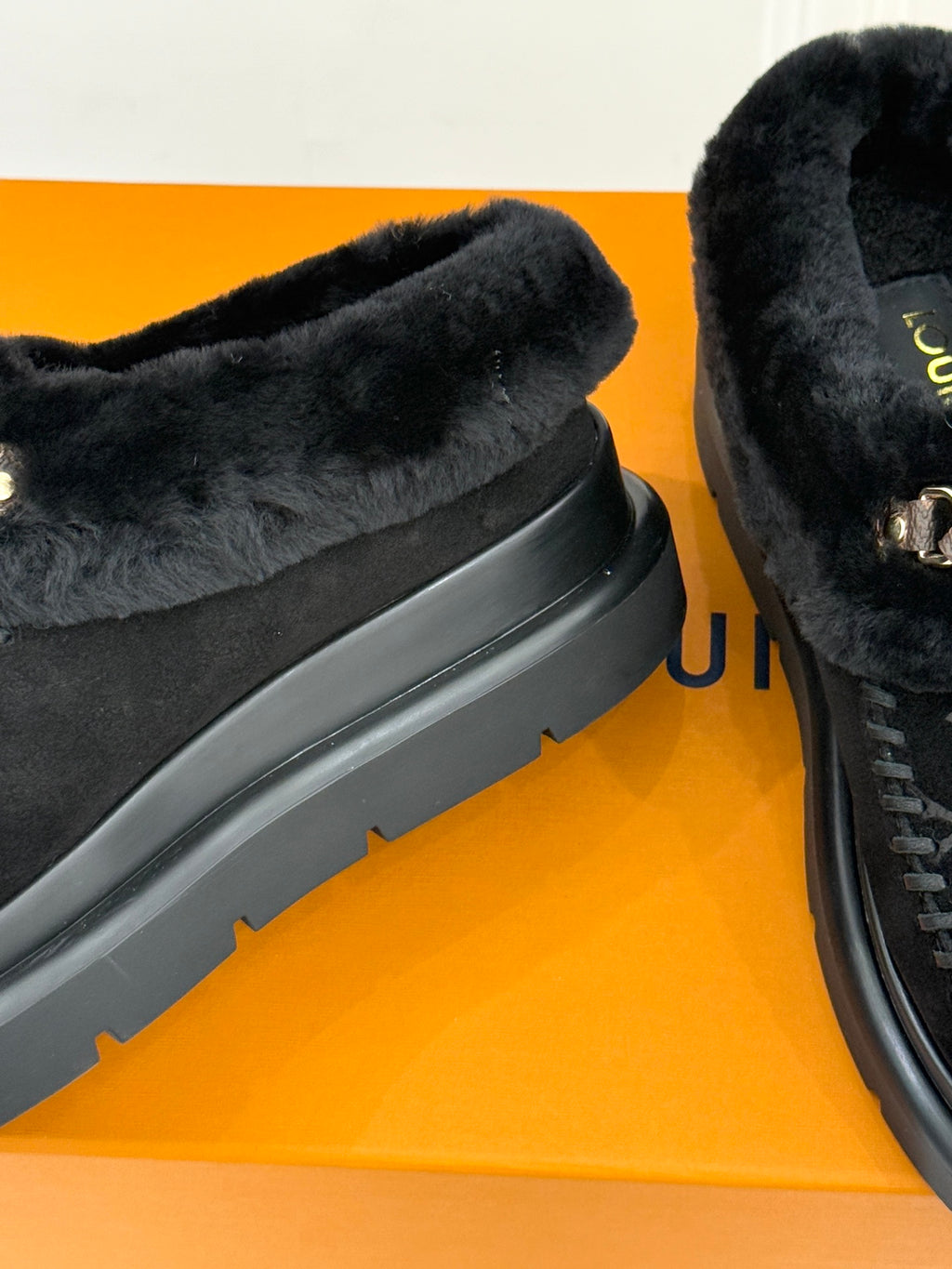 Black shearling upper and textured platform sole on a pair of monogram loafers