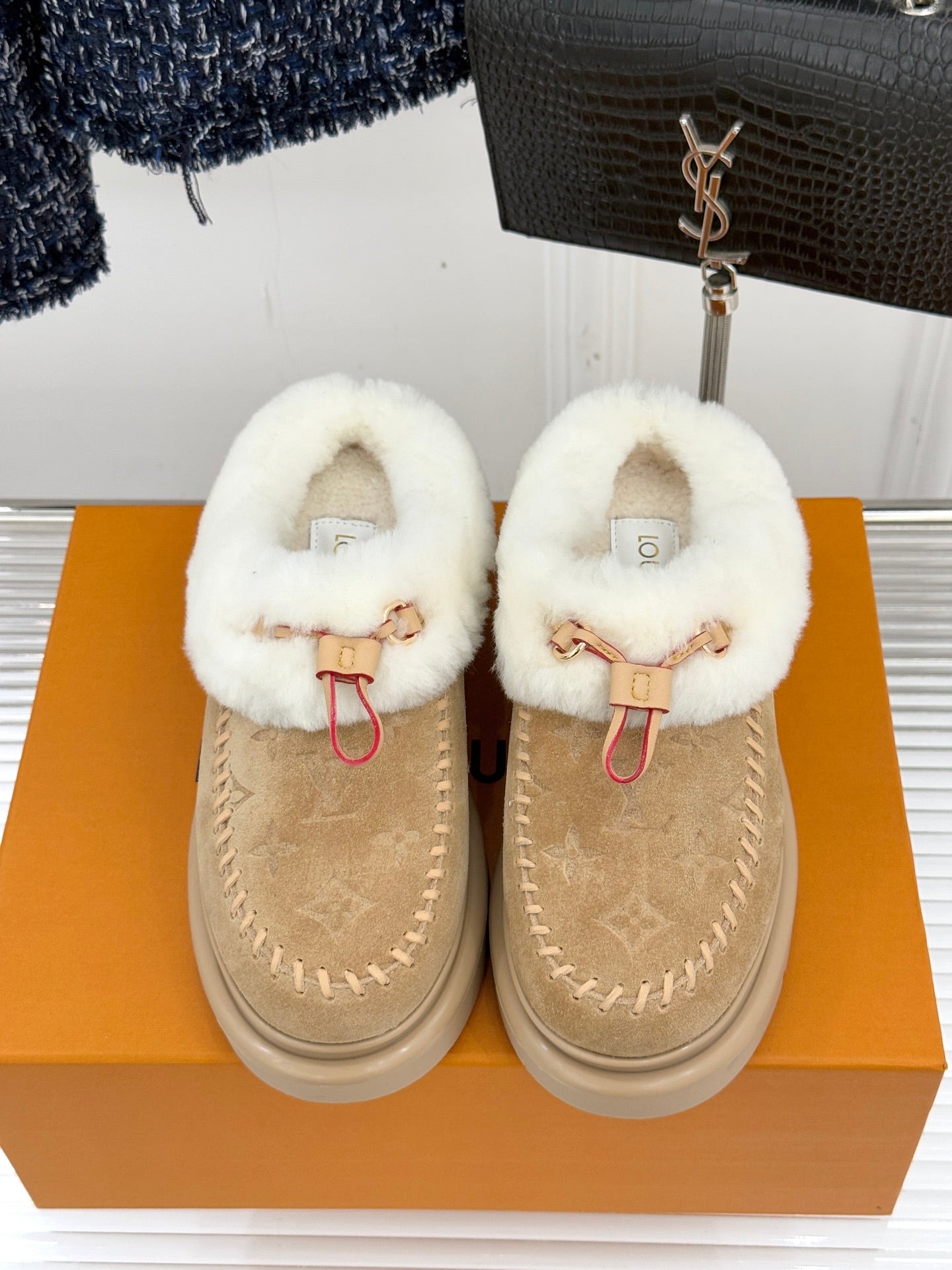 Ladies Louis Vuitton tan suede mules with white shearling straps and red ties