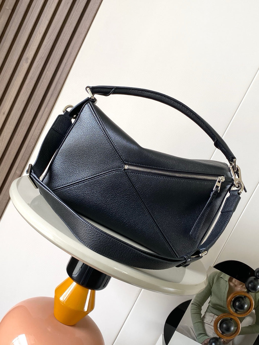 Dark blue leather shoulder bag with curved handle, braided trim, and silver-tone clasp