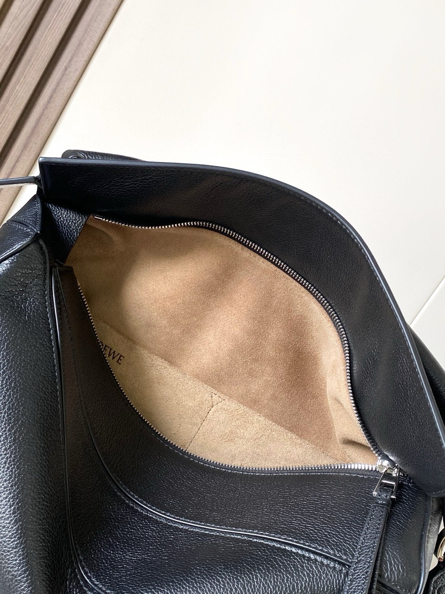 Dark blue leather shoulder bag with zip-top opening and suede-lined interior