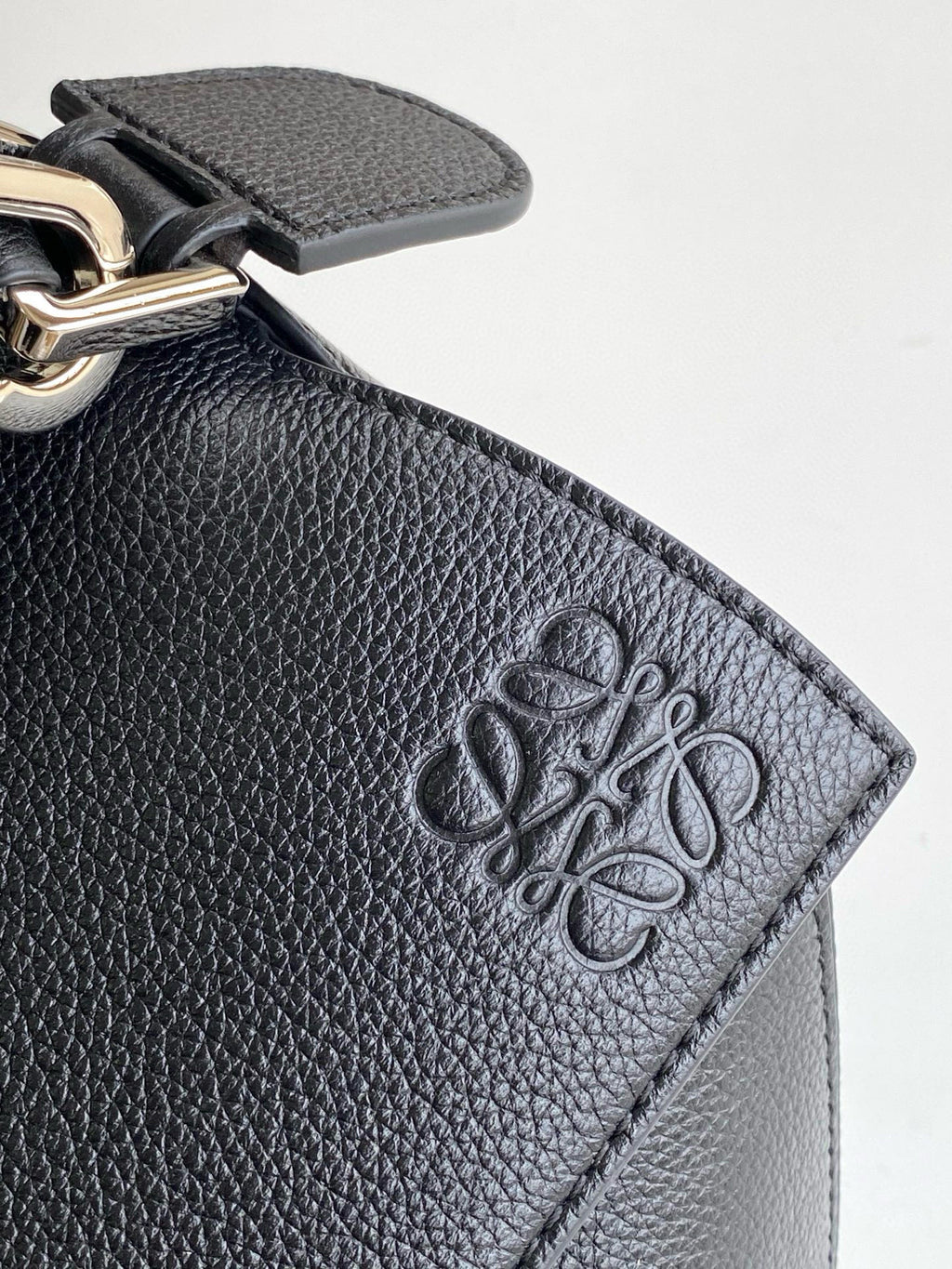 Loewe men's bag logo on textured dark blue leather patch, metal clasp detail