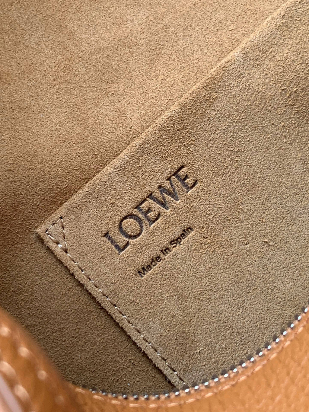 Tan suede-like inner panel with LOEWE stamped text and dotted edge stitching.