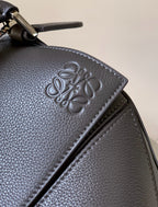 Loewe bag corner detail with embossed logo on dark blue-gray textured leather
