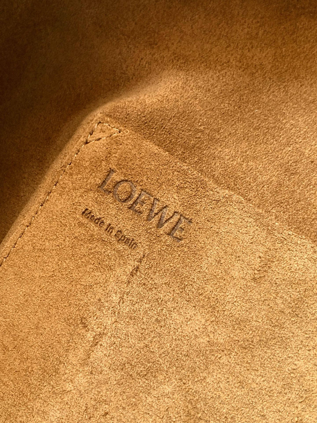 Loewe logo stamp on tan suede lining inside the bag, with embossed text detail