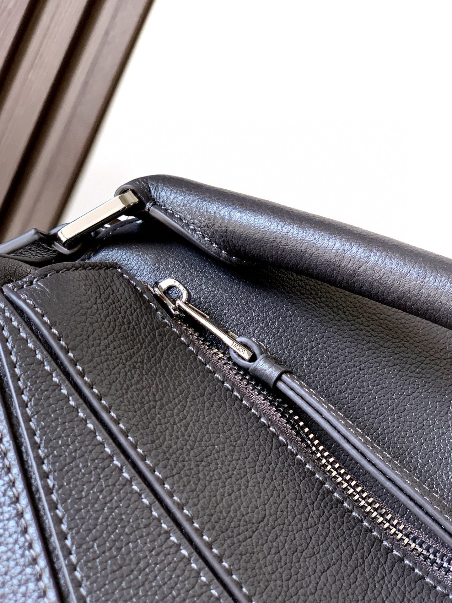 Loewe bag side panel detail with stitched seams and zipper track on dark leather
