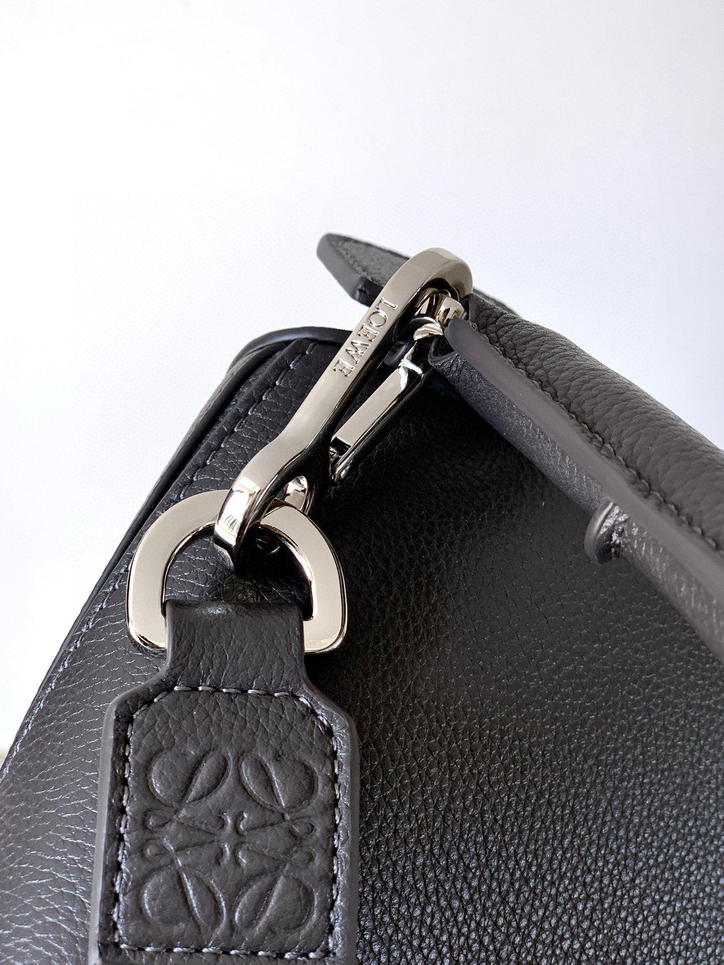 Loewe bag top hardware close-up with zipper pull and embossed leather tag