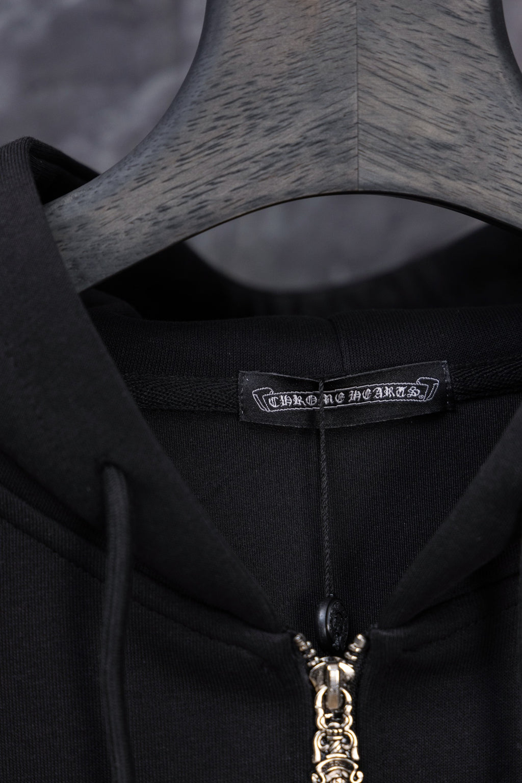 Black long zip hoodie neckline with zipper charm and woven brand label
