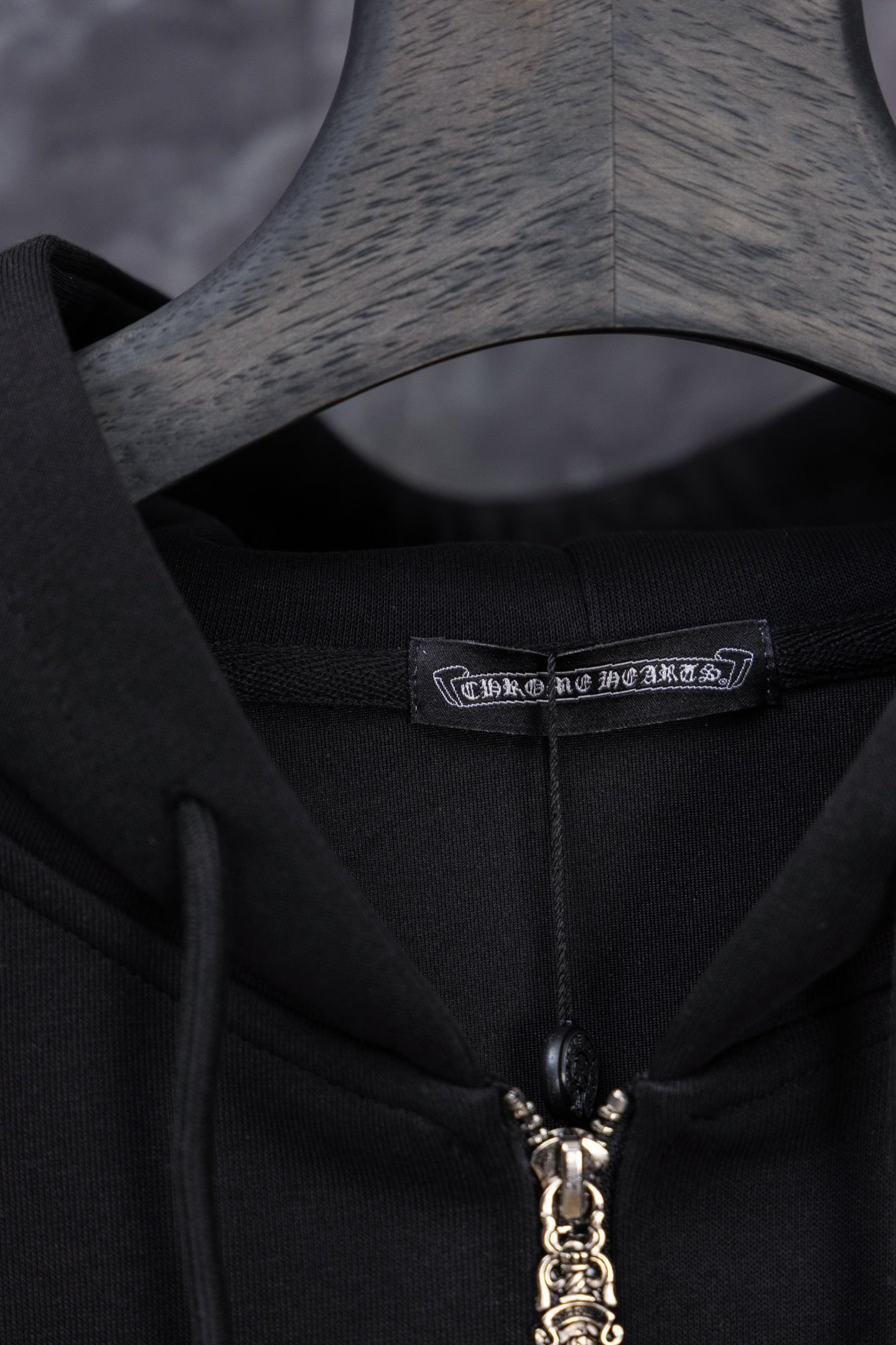 Black long zip hoodie neckline with zipper charm and woven brand label