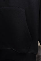 Black hoodie front pocket with curved side seam and ribbed cuff trim